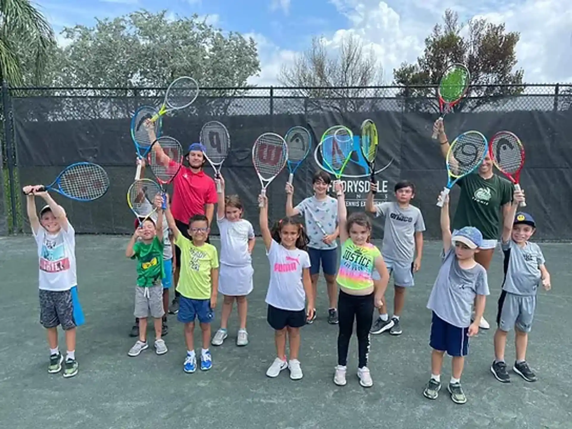 a group of kids holding tennis rackets