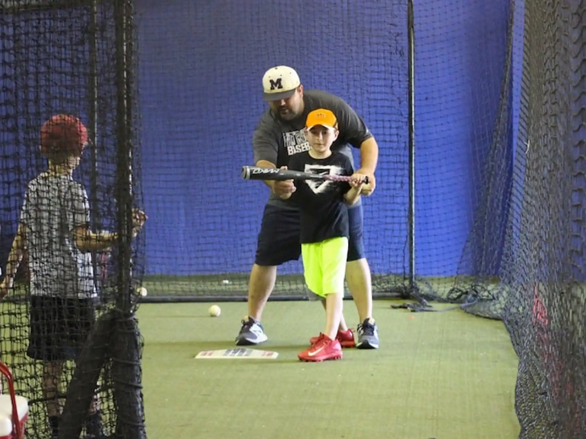 a boy hitting a ball with a baseball bat