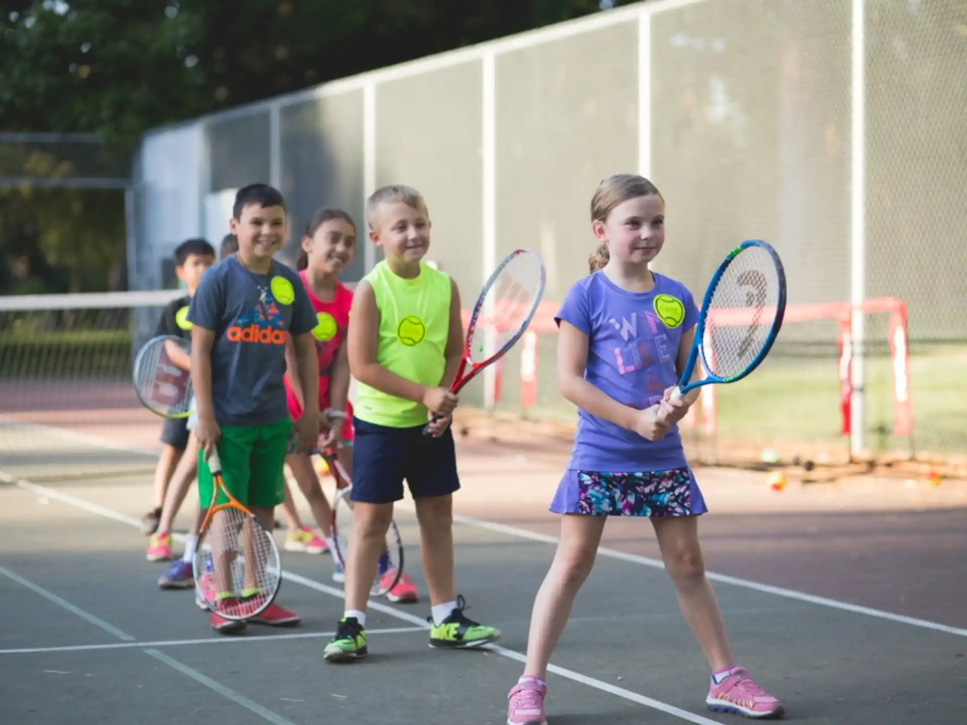 a group of kids holding tennis rackets