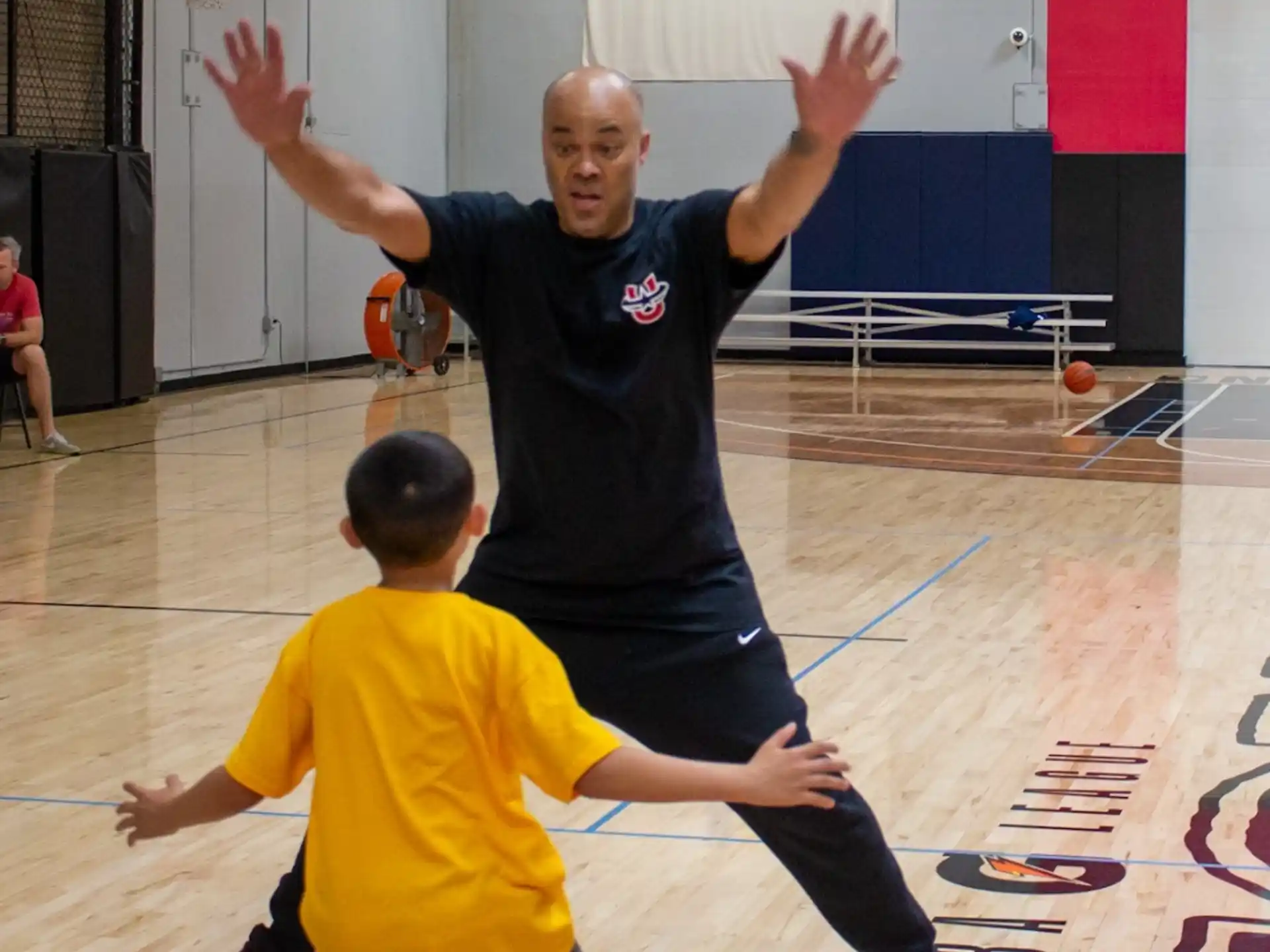 a person and a boy playing basketball