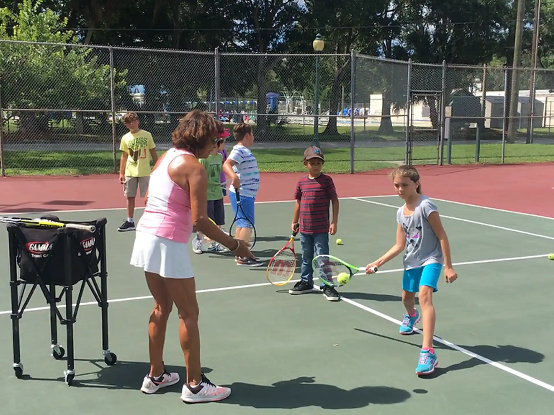 a group of kids playing tennis