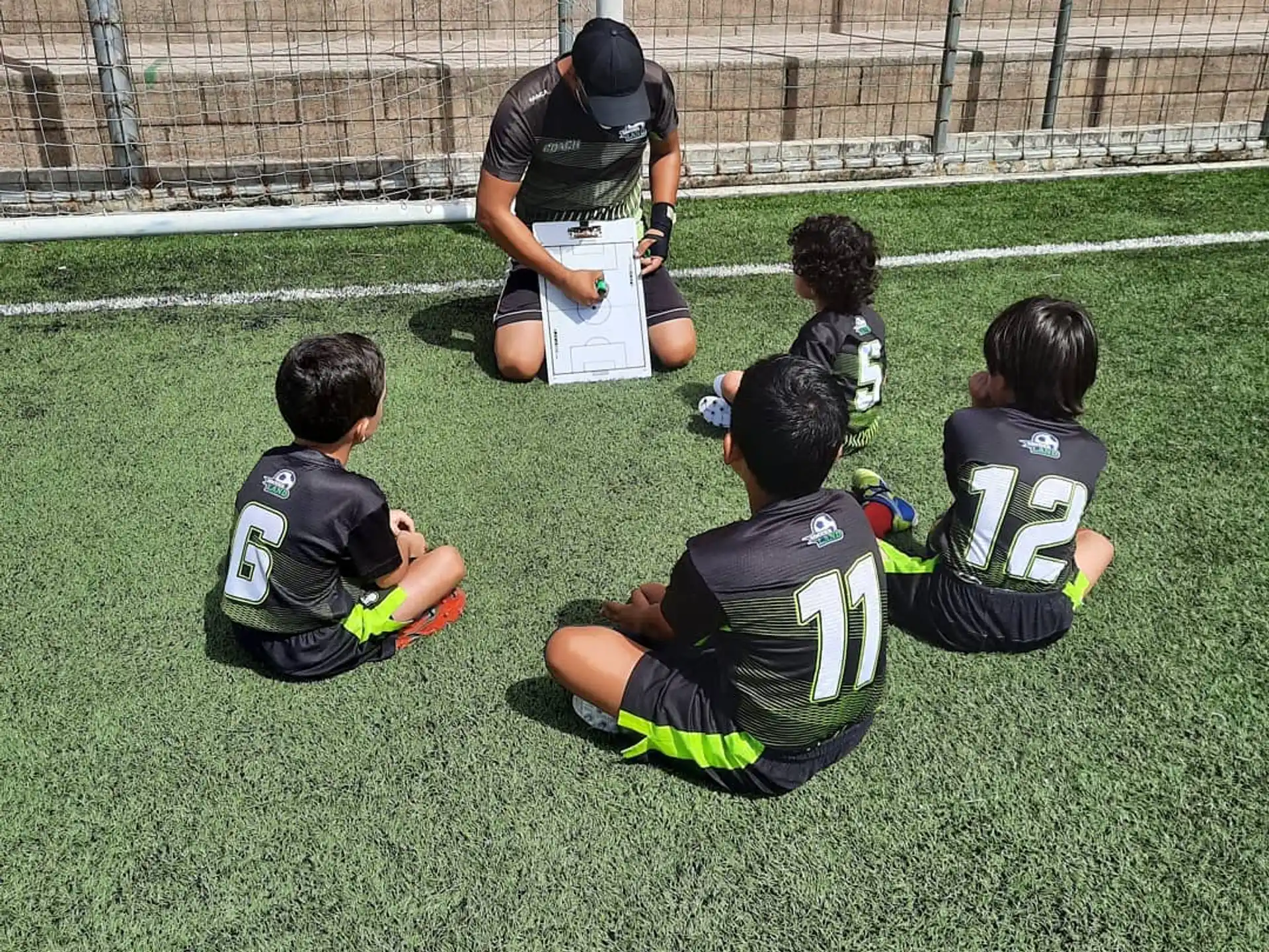 a group of kids kneeling on the grass