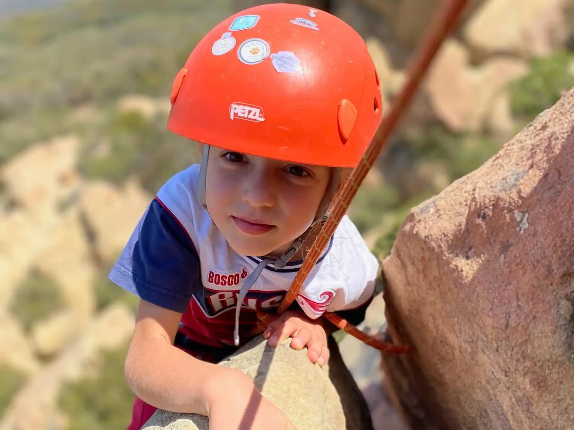 a young boy climbing a rock