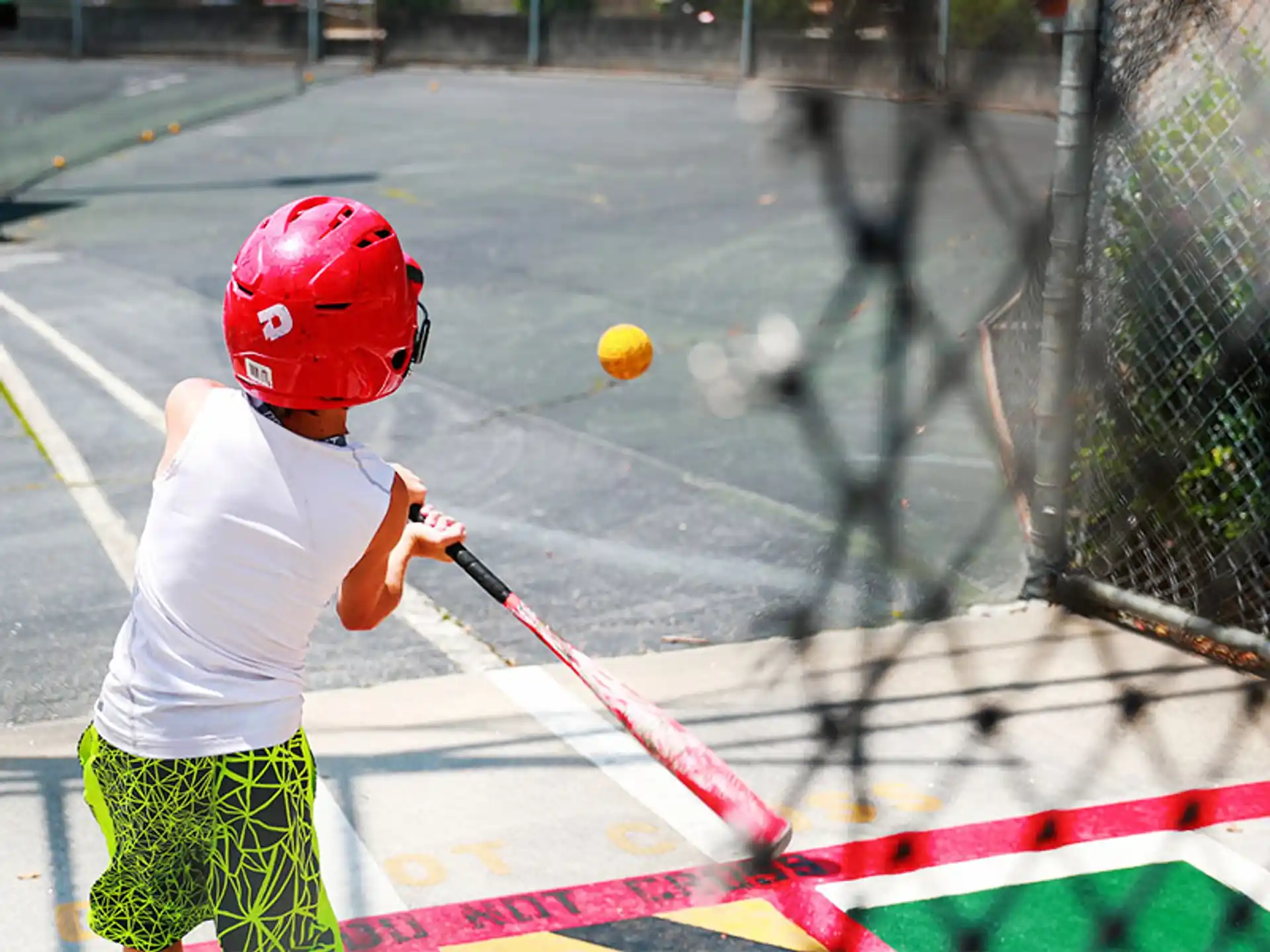 a kid hitting a ball with a baseball bat
