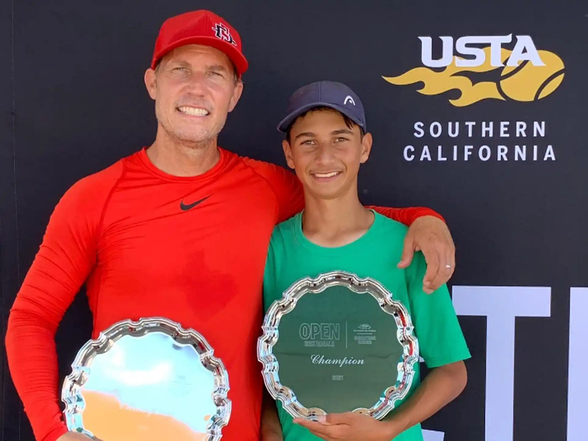 a person and a boy holding a trophy