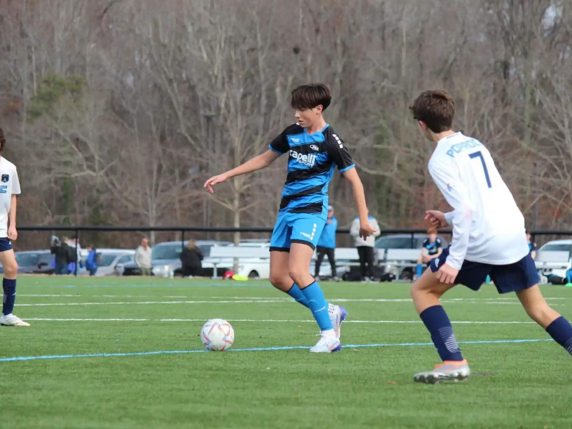 a group of boys compete over a football ball