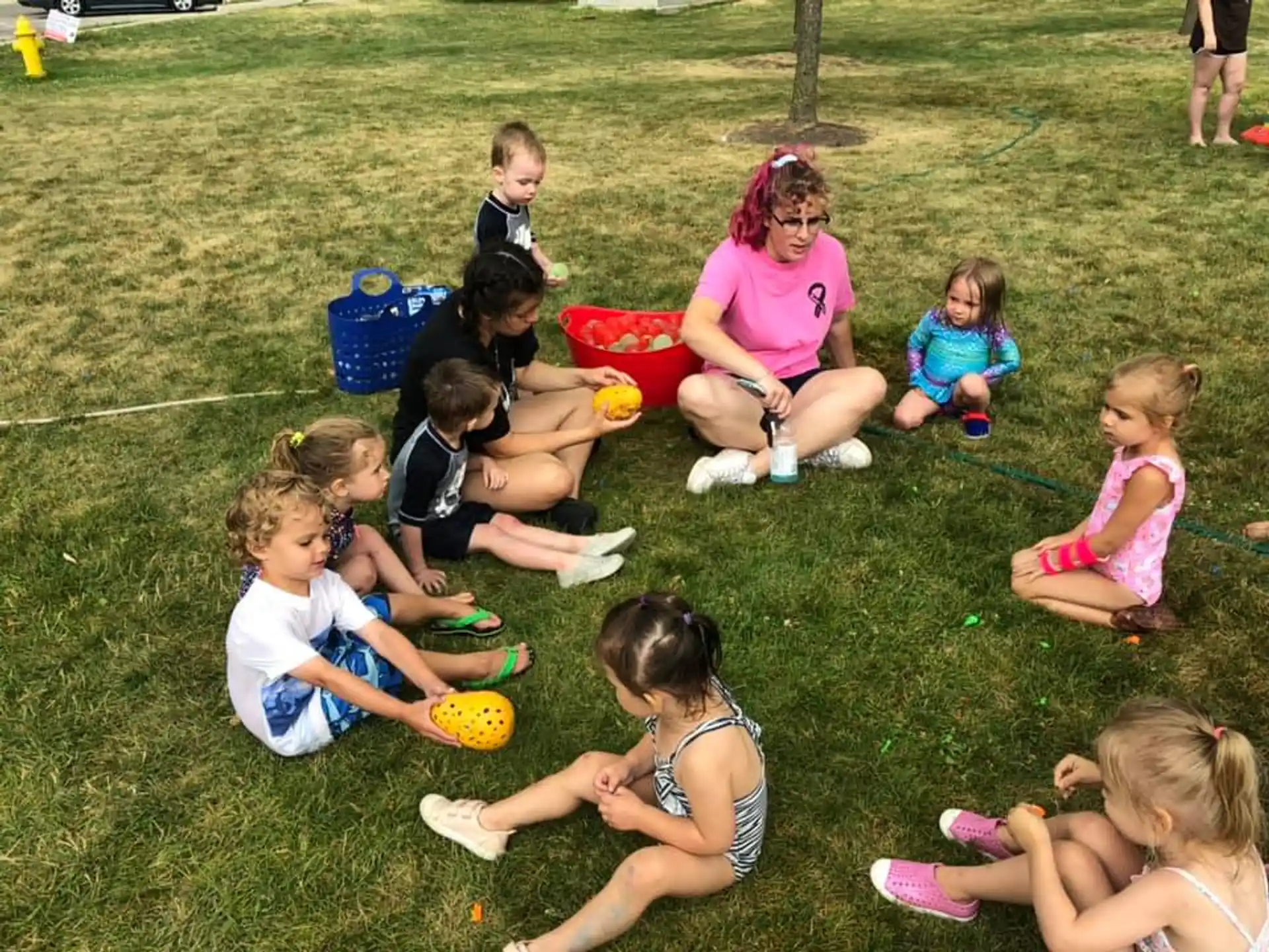 a group of children sitting on the grass
