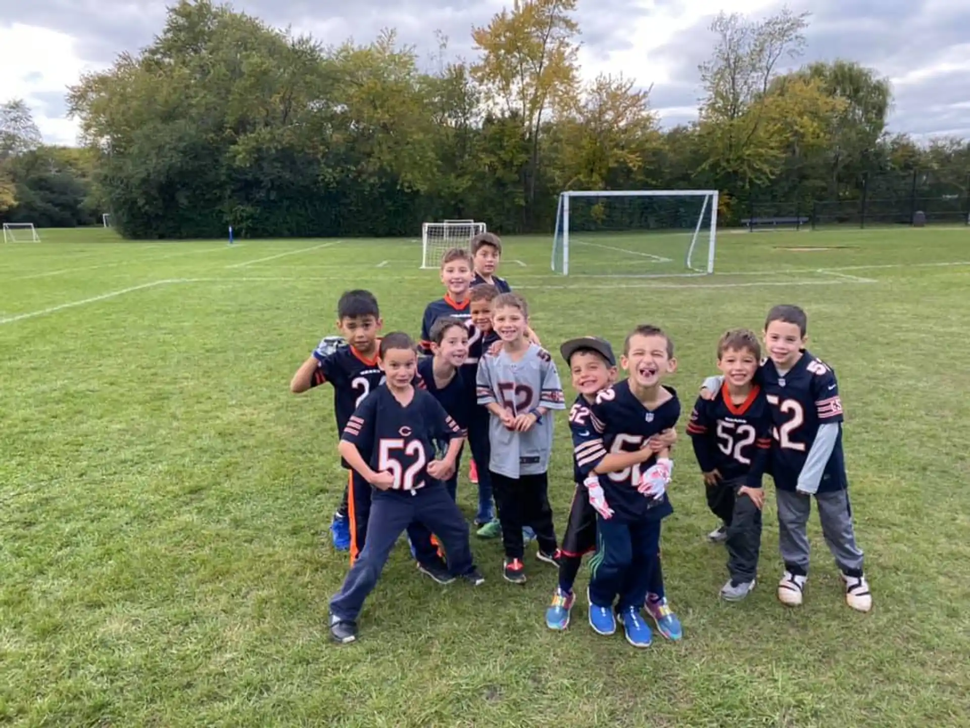 a group of kids posing for a picture on a football field