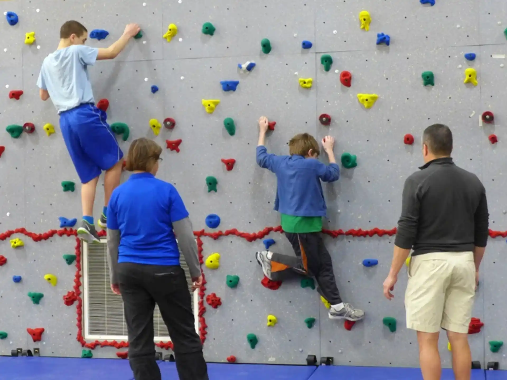 a group of people climbing a rock wall