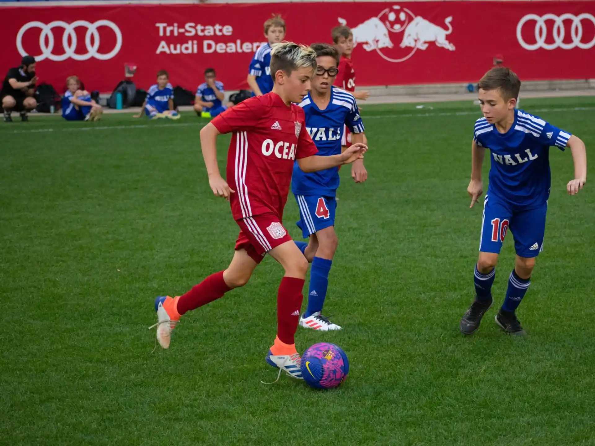 a group of kids compete over a football ball