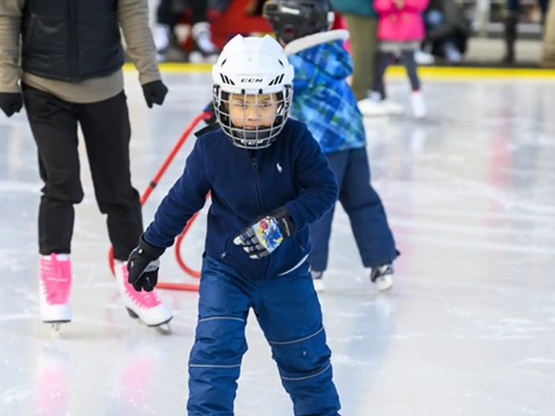 a child wearing a hockey uniform and holding a hockey stick