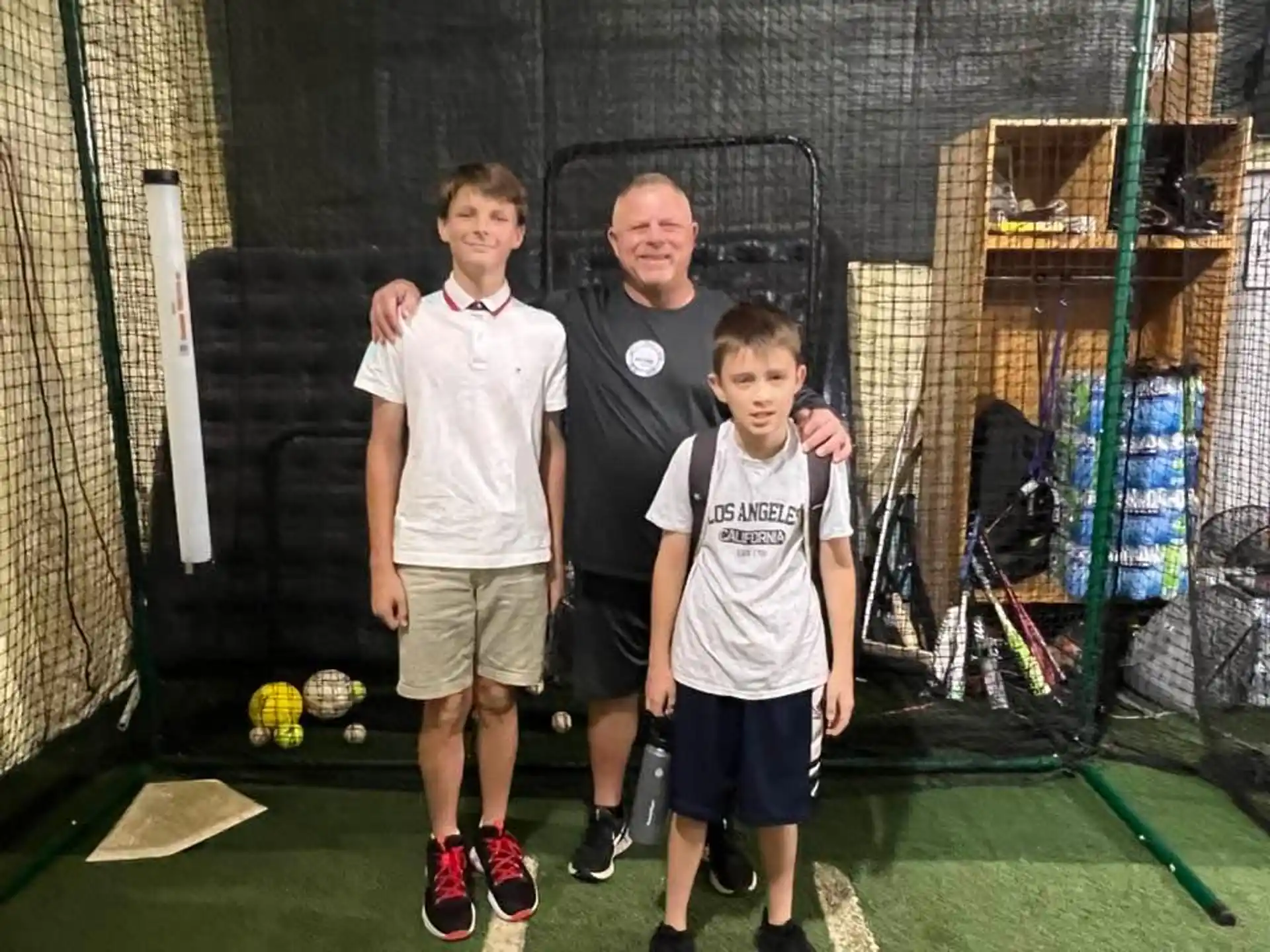 a group of boys posing for a picture in front of a cage