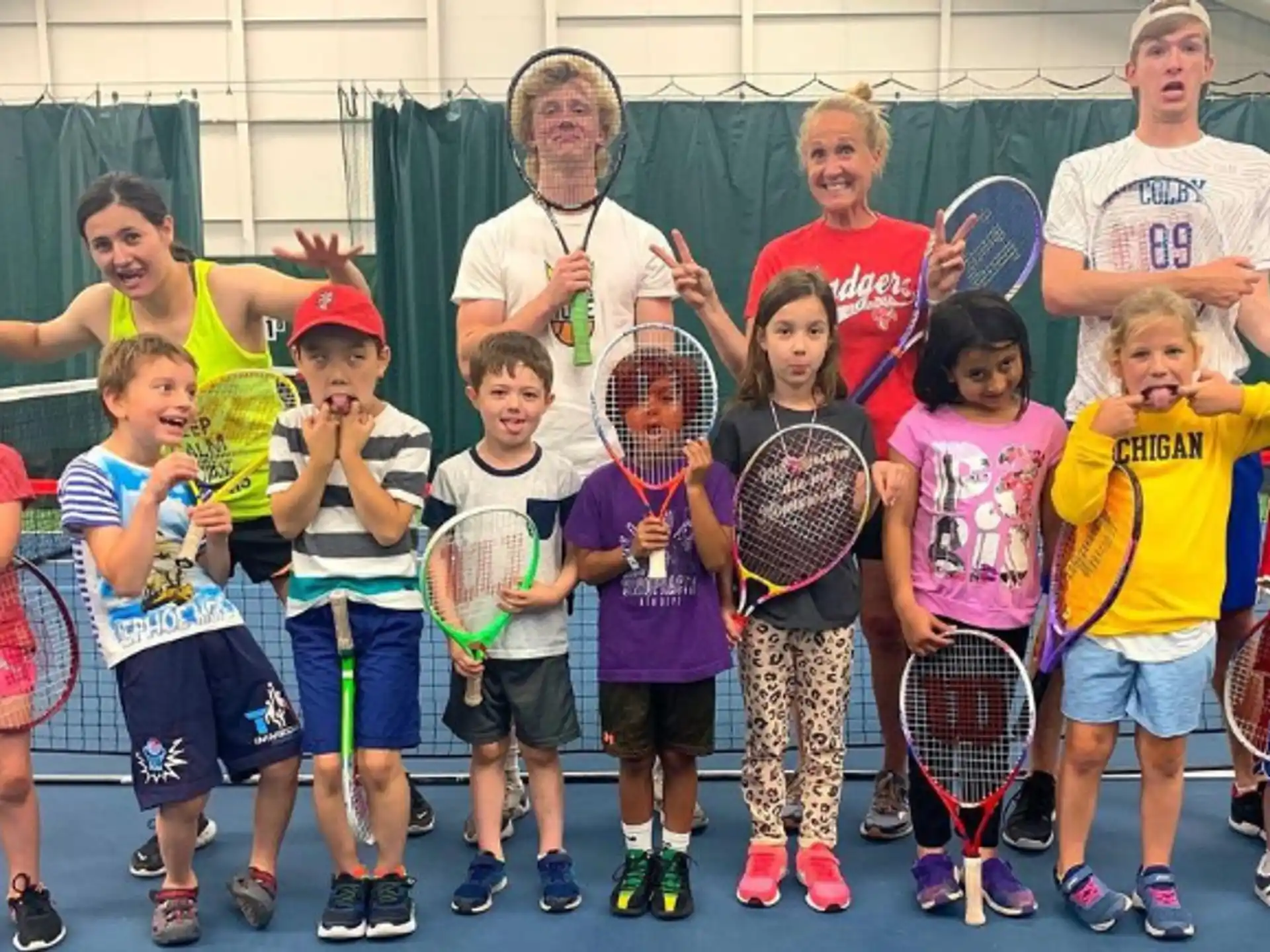 a group of kids holding tennis rackets