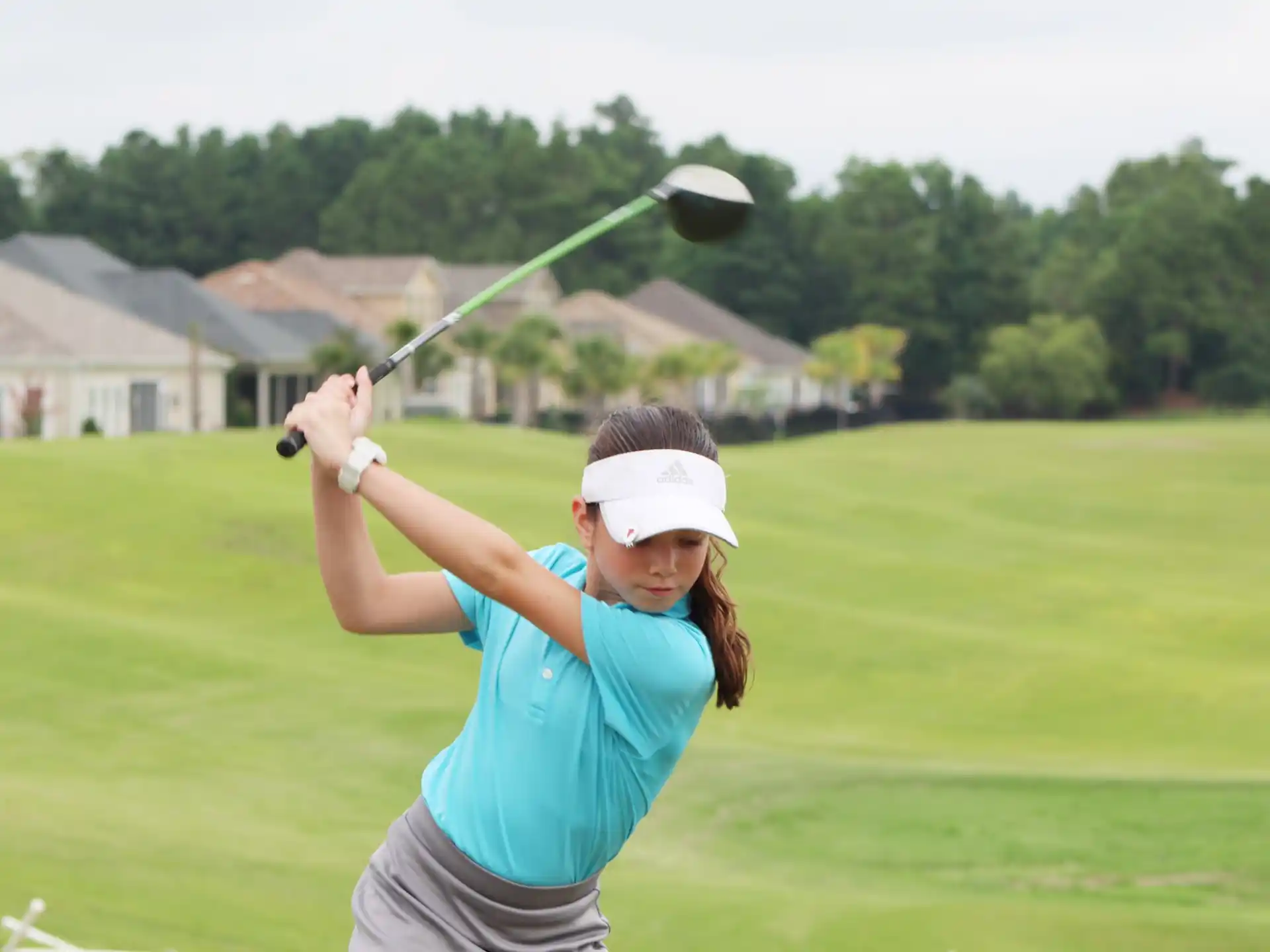 a woman swinging a golf club