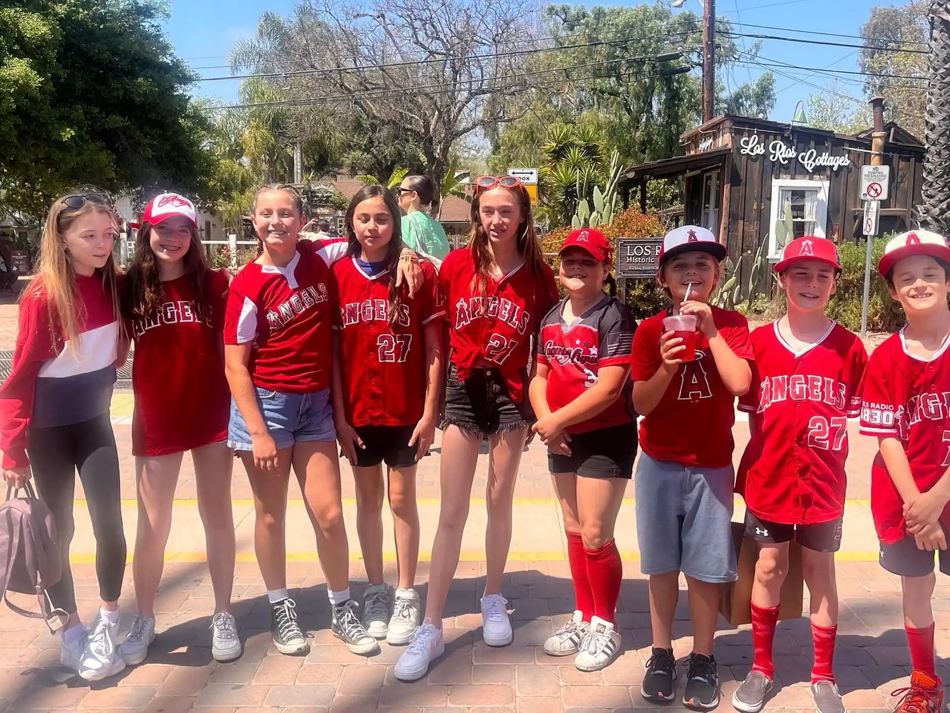 a group of people wearing matching t-shirts and standing on a sidewalk
