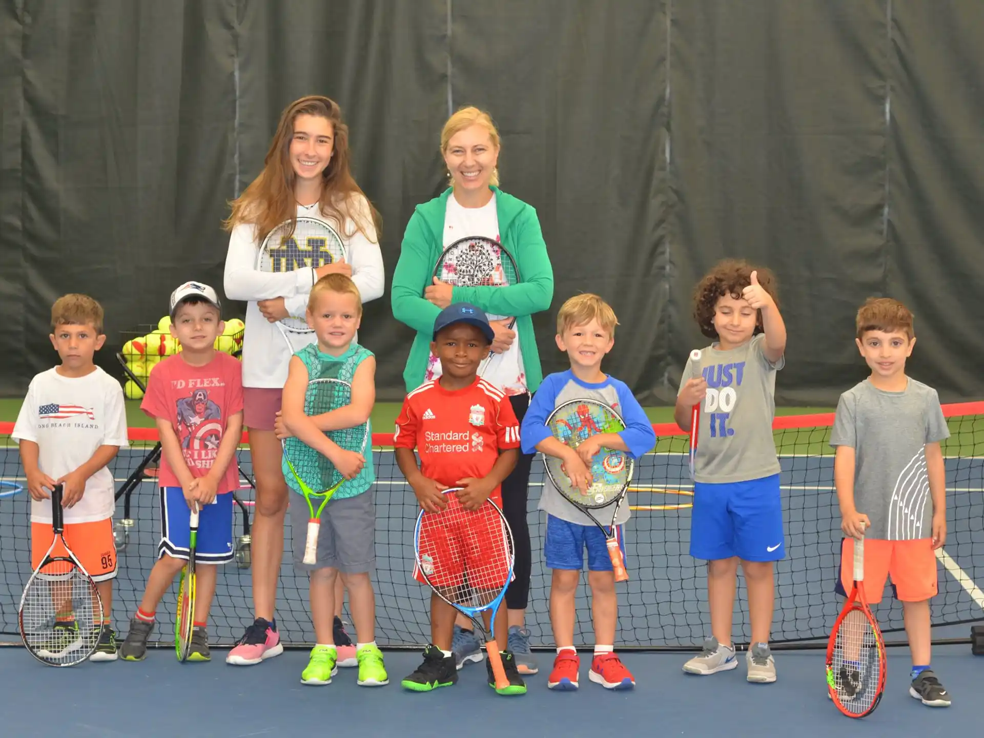 a group of kids holding tennis rackets