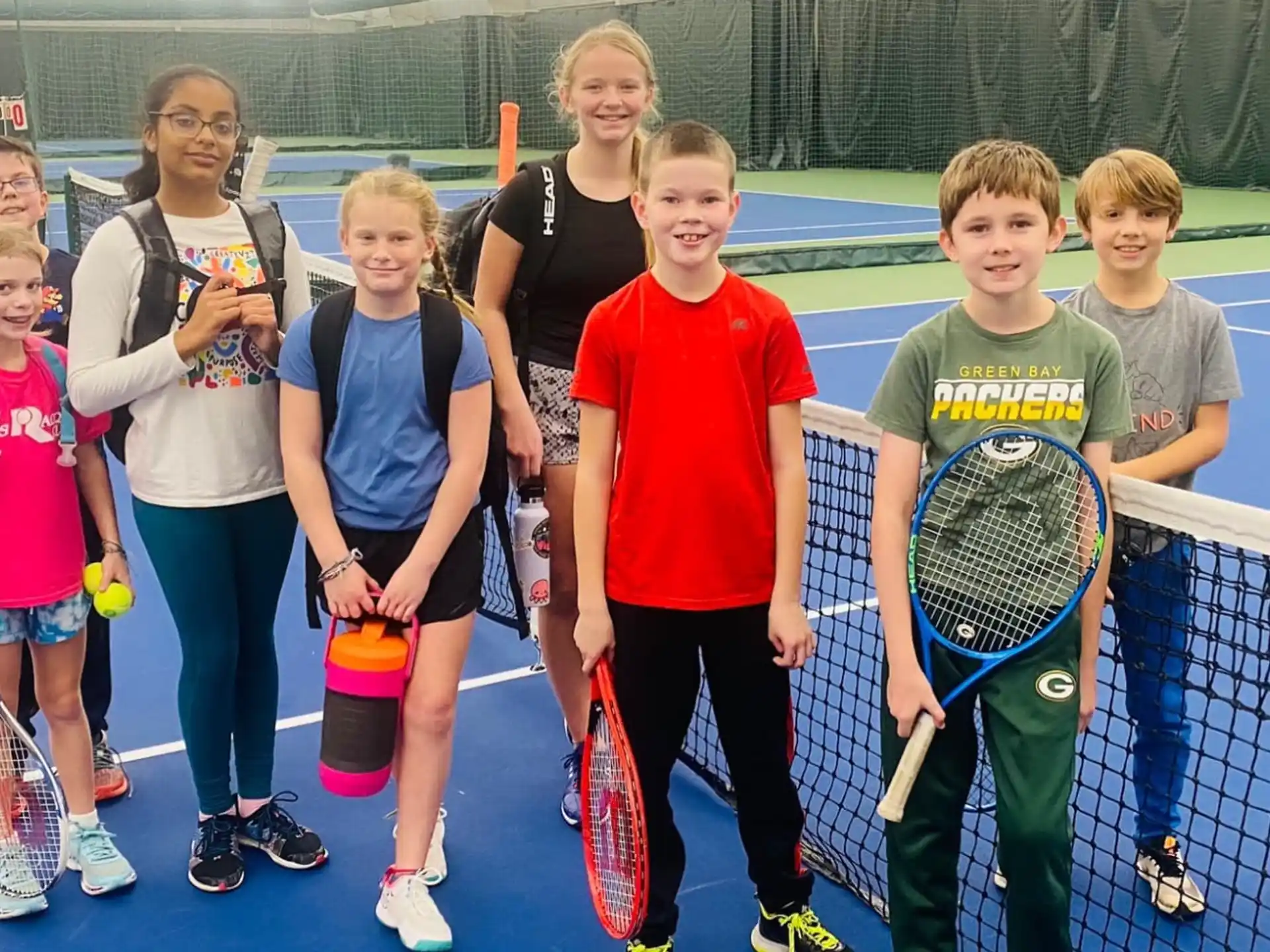 a group of kids holding tennis rackets