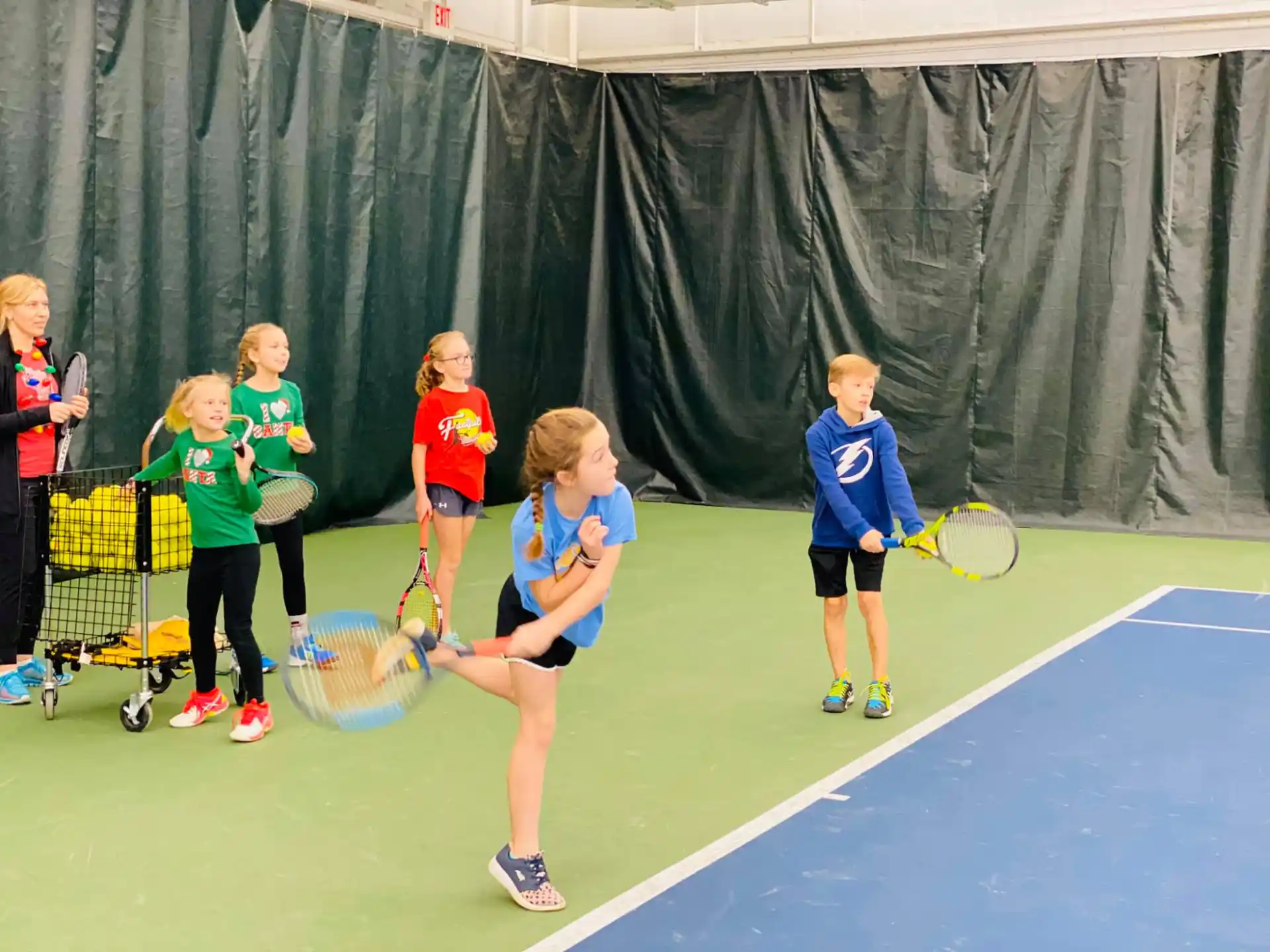 a group of kids playing tennis