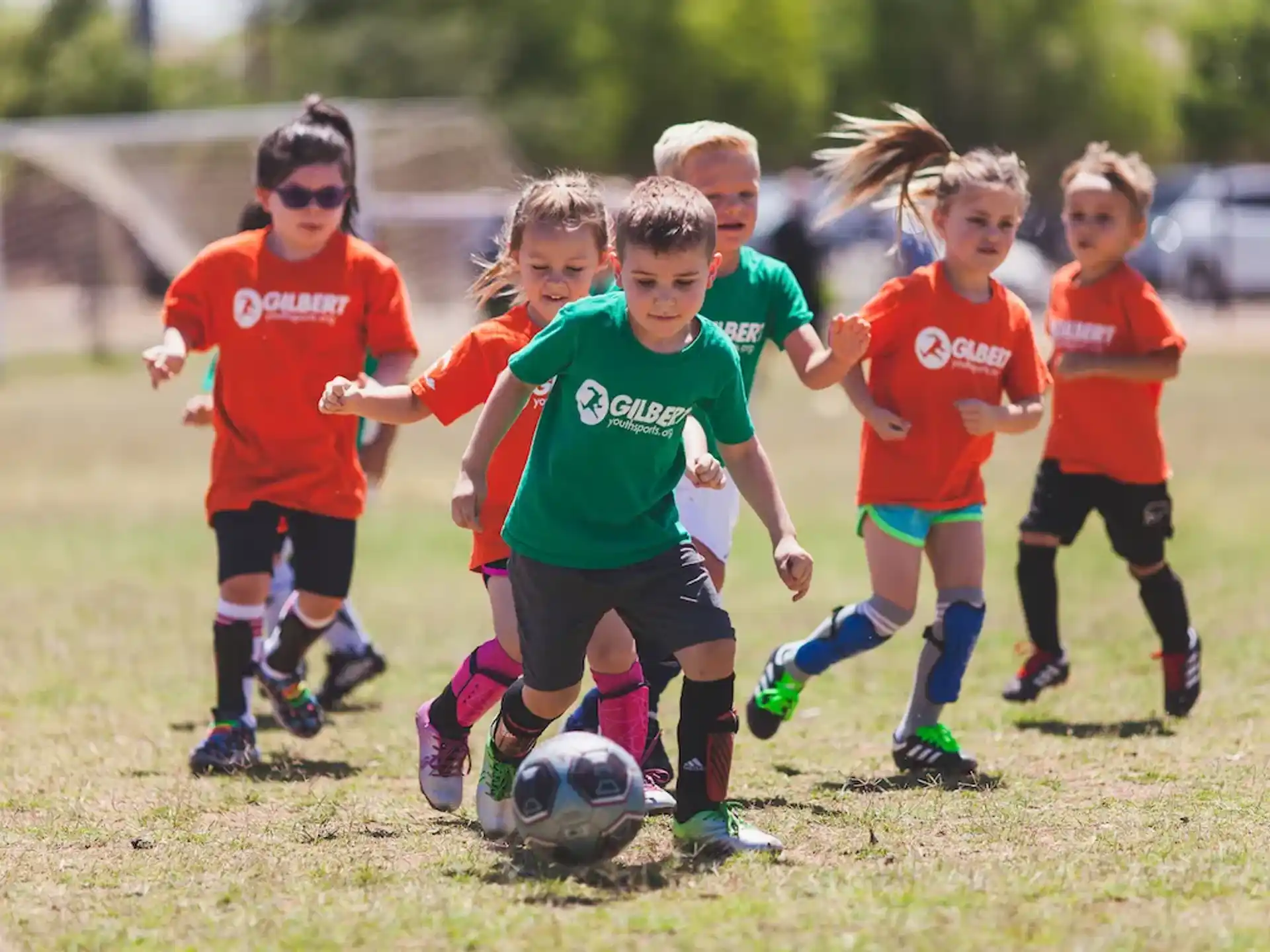 a group of kids compete over a football ball