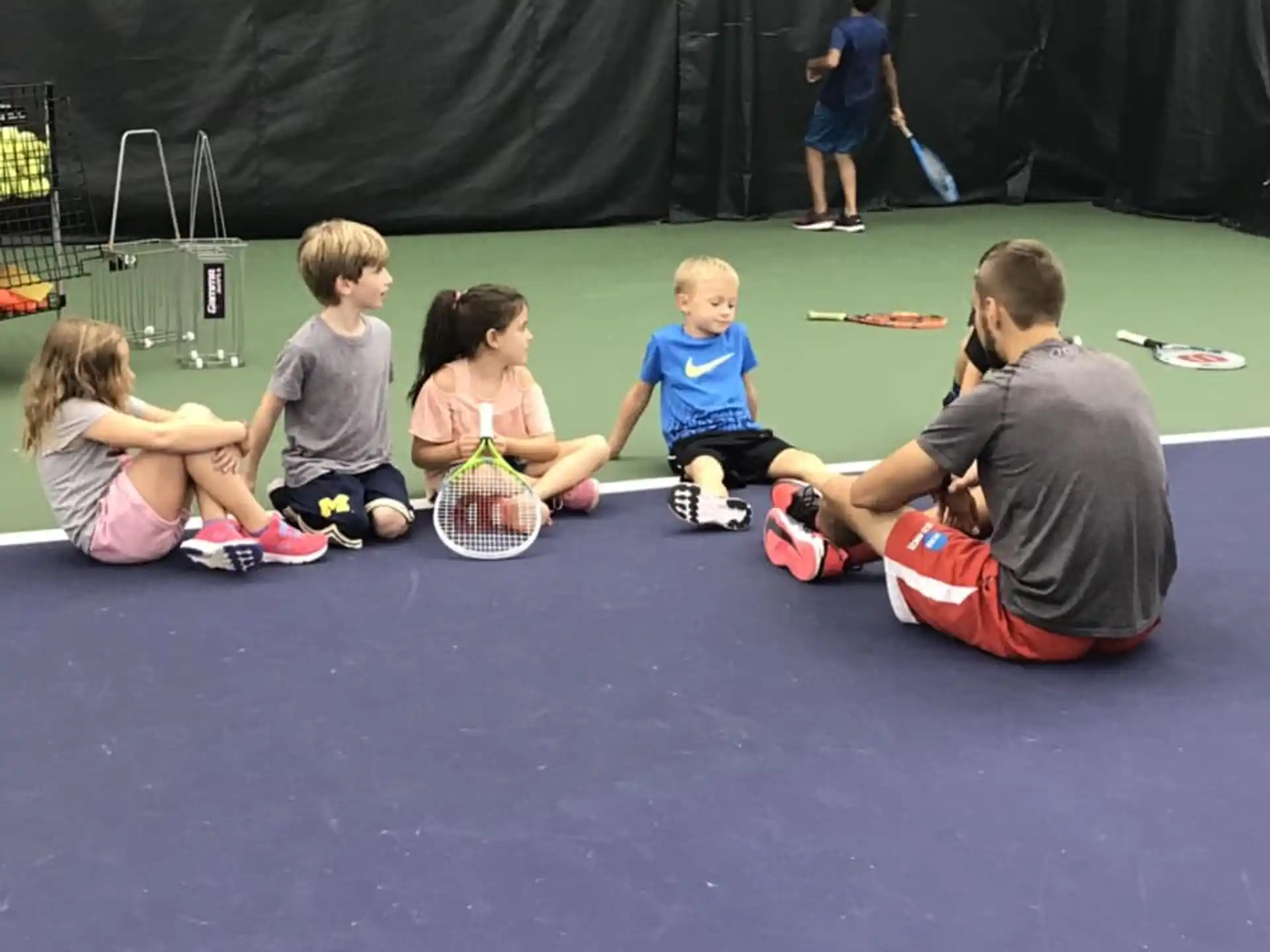a group of kids playing tennis