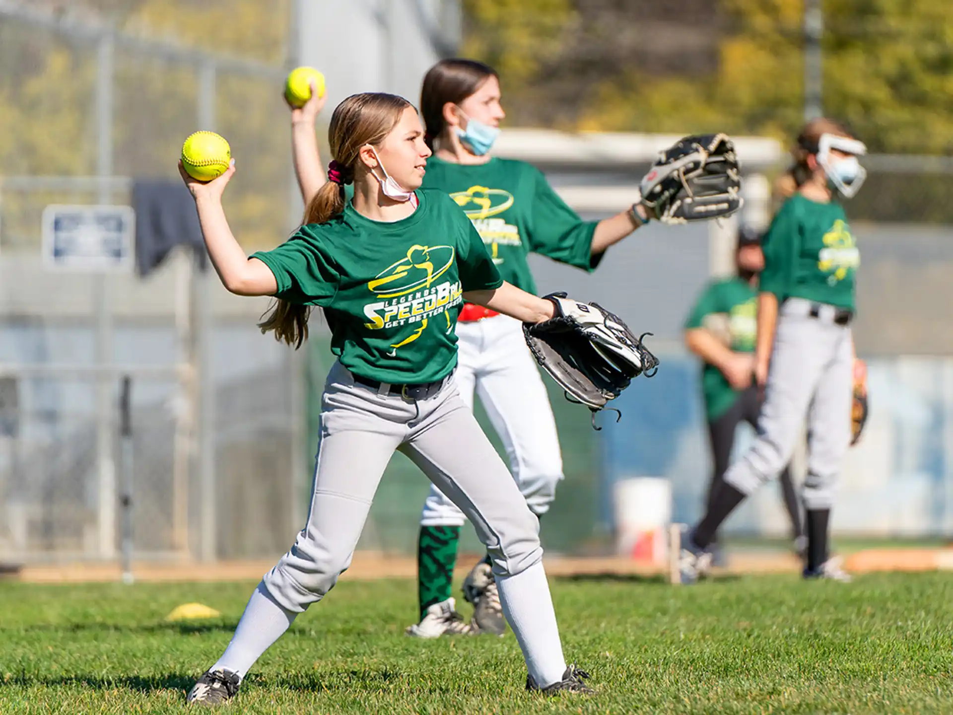 girls playing softball on a field
