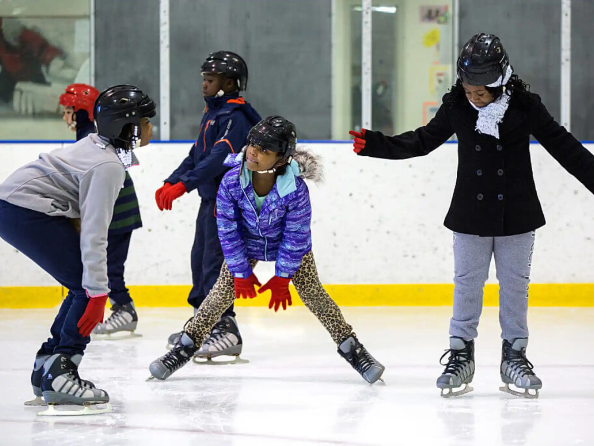 a group of people wearing helmets and ice skates