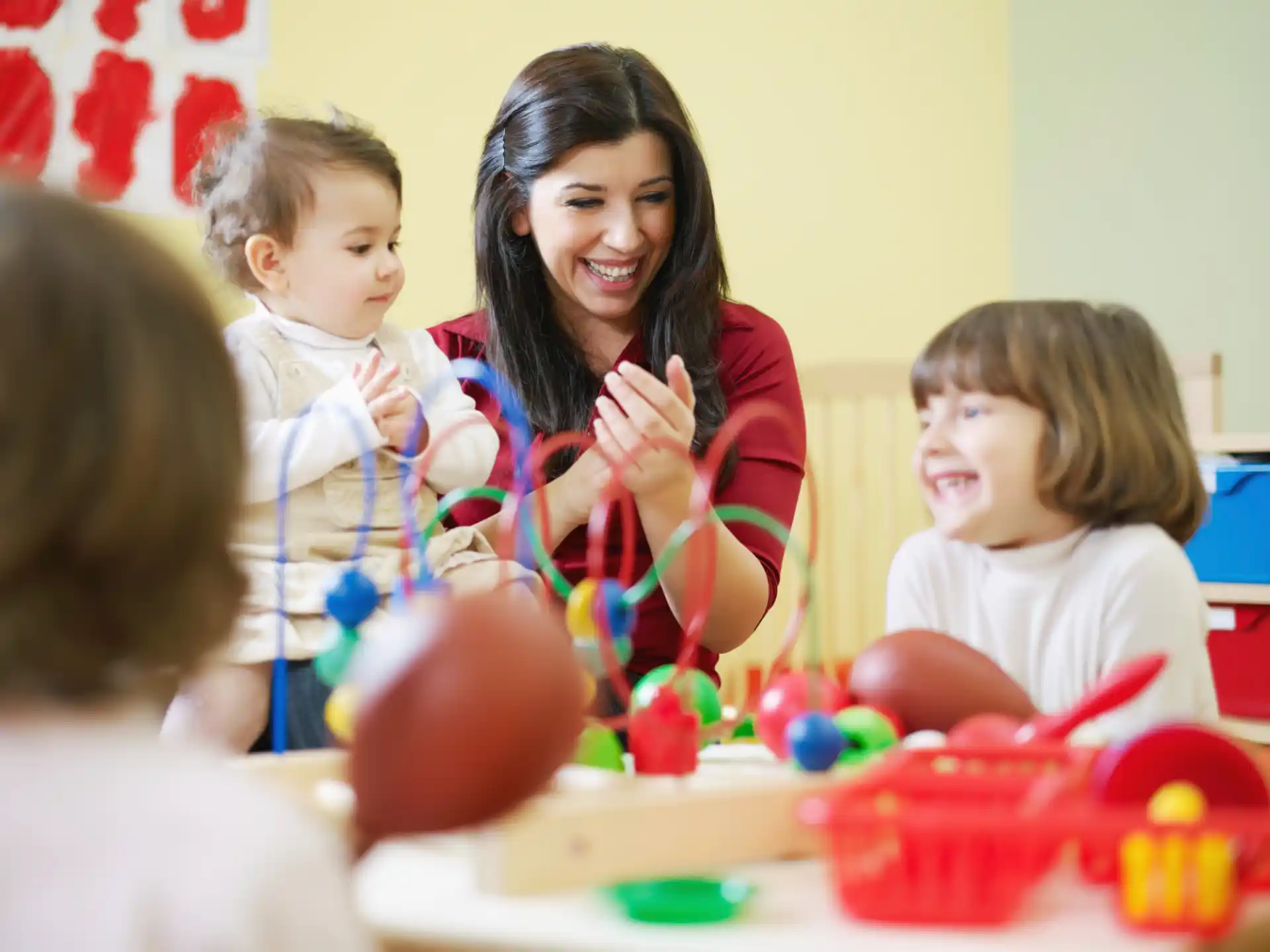 a person and children sitting at a table with balls