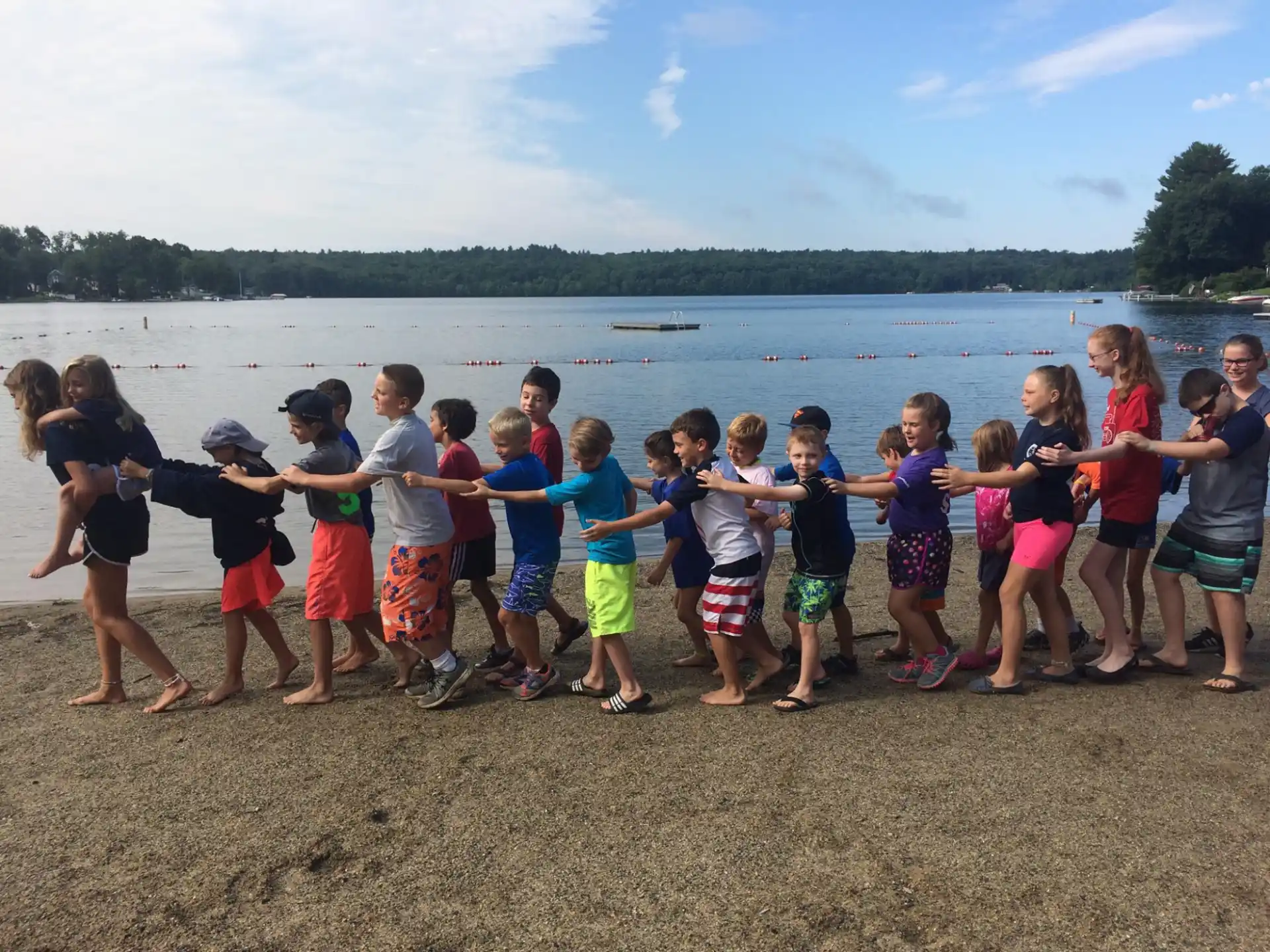 a group of kids standing on a beach