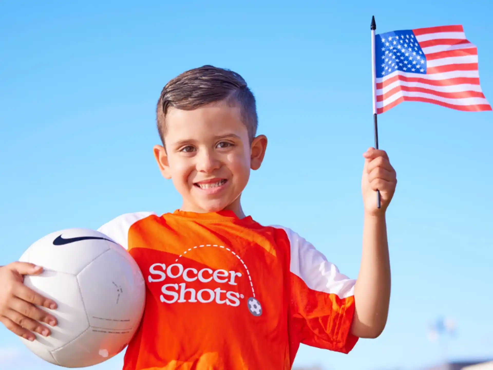 a boy holding a football ball and a flag