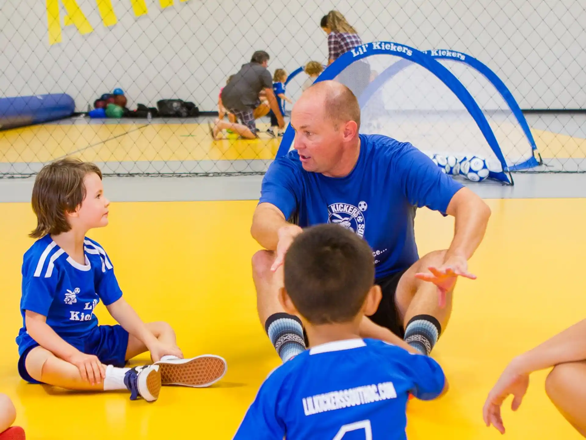 a person and two boys playing a game on a yellow floor