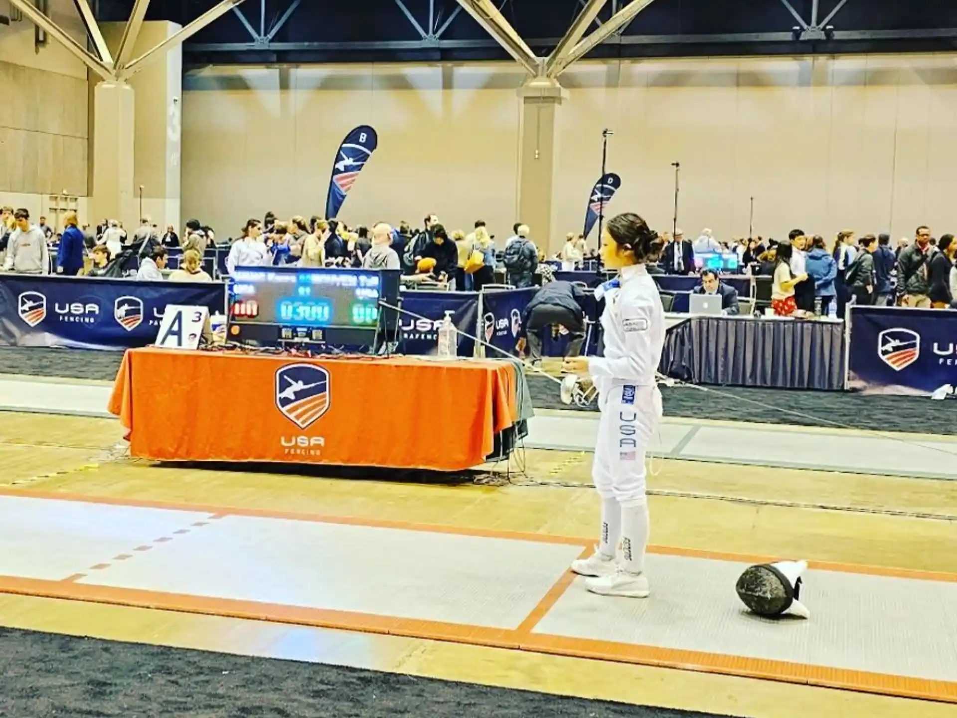 a person in a white uniform on a mat in front of a crowd