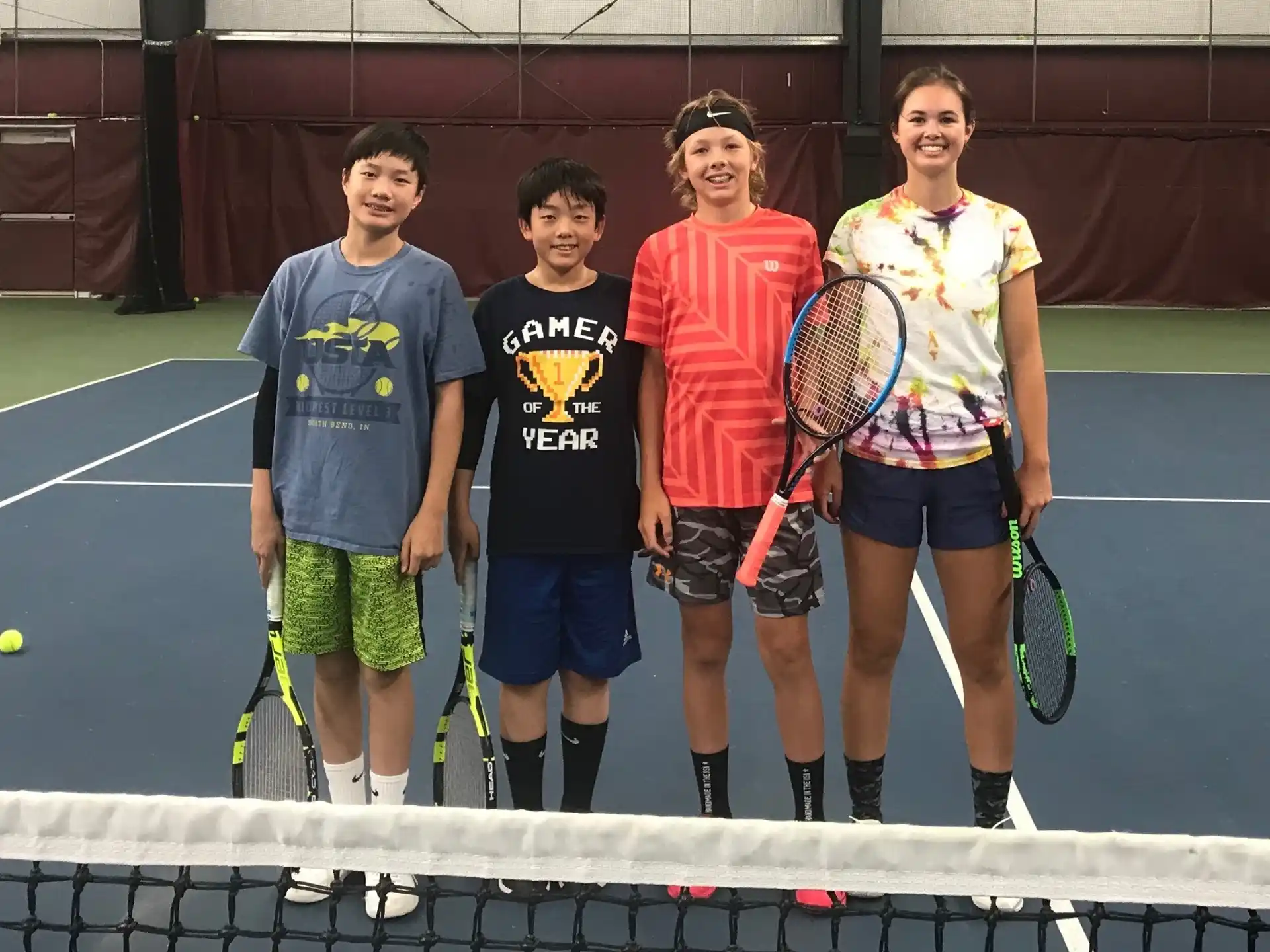 a group of kids holding tennis rackets