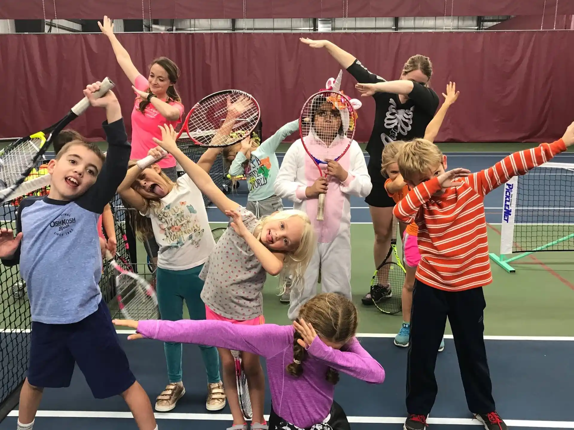 a group of kids playing tennis