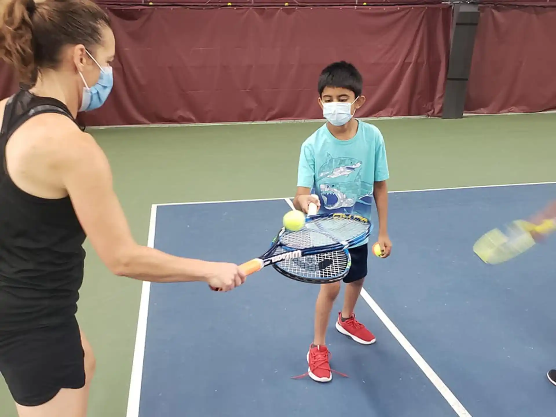 a woman and a boy playing tennis