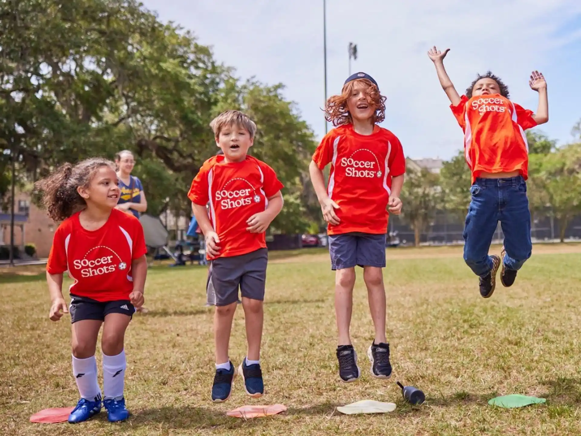 a group of kids in red shirts running on a field