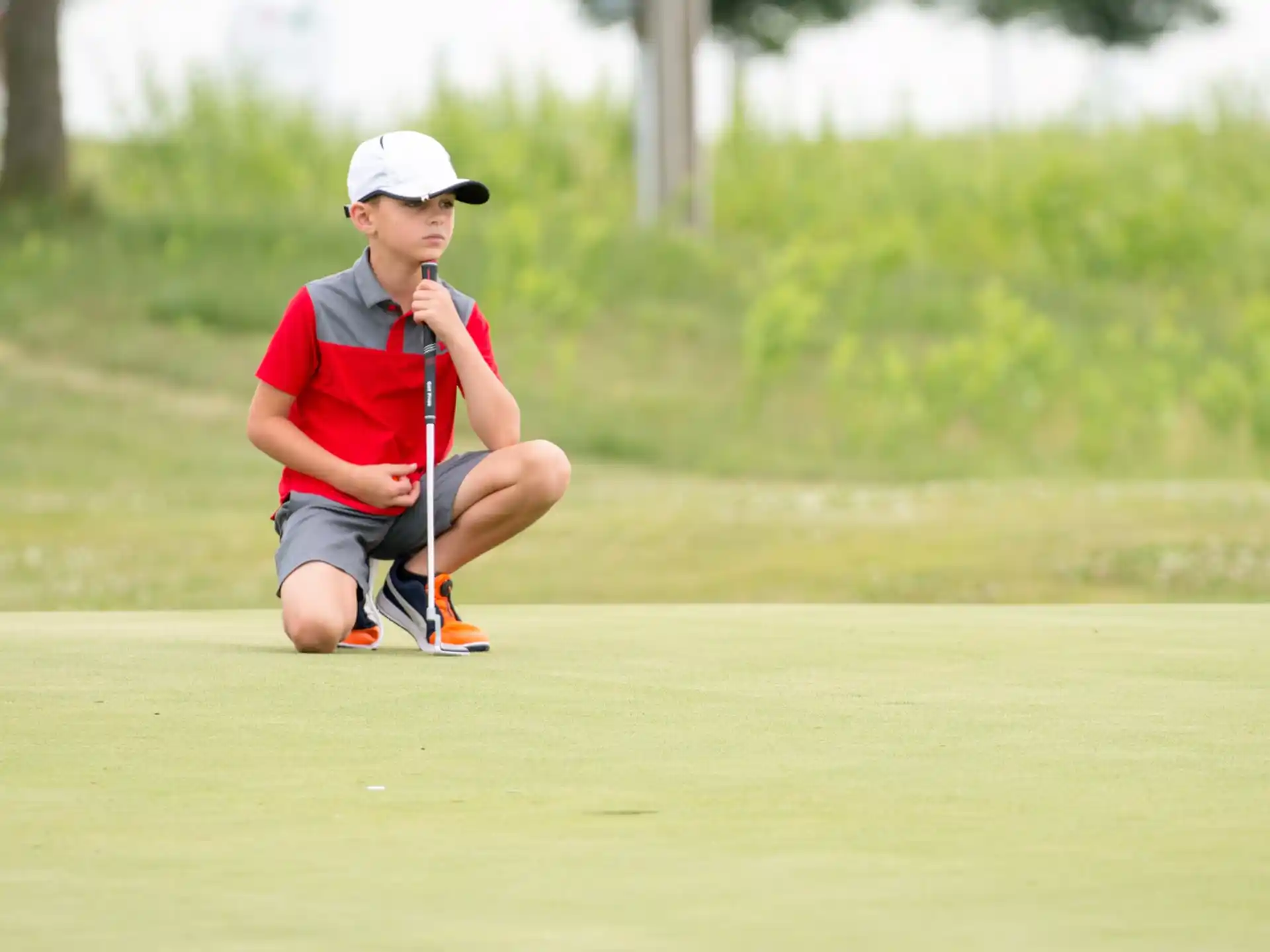 a man sitting on the ground with a golf club