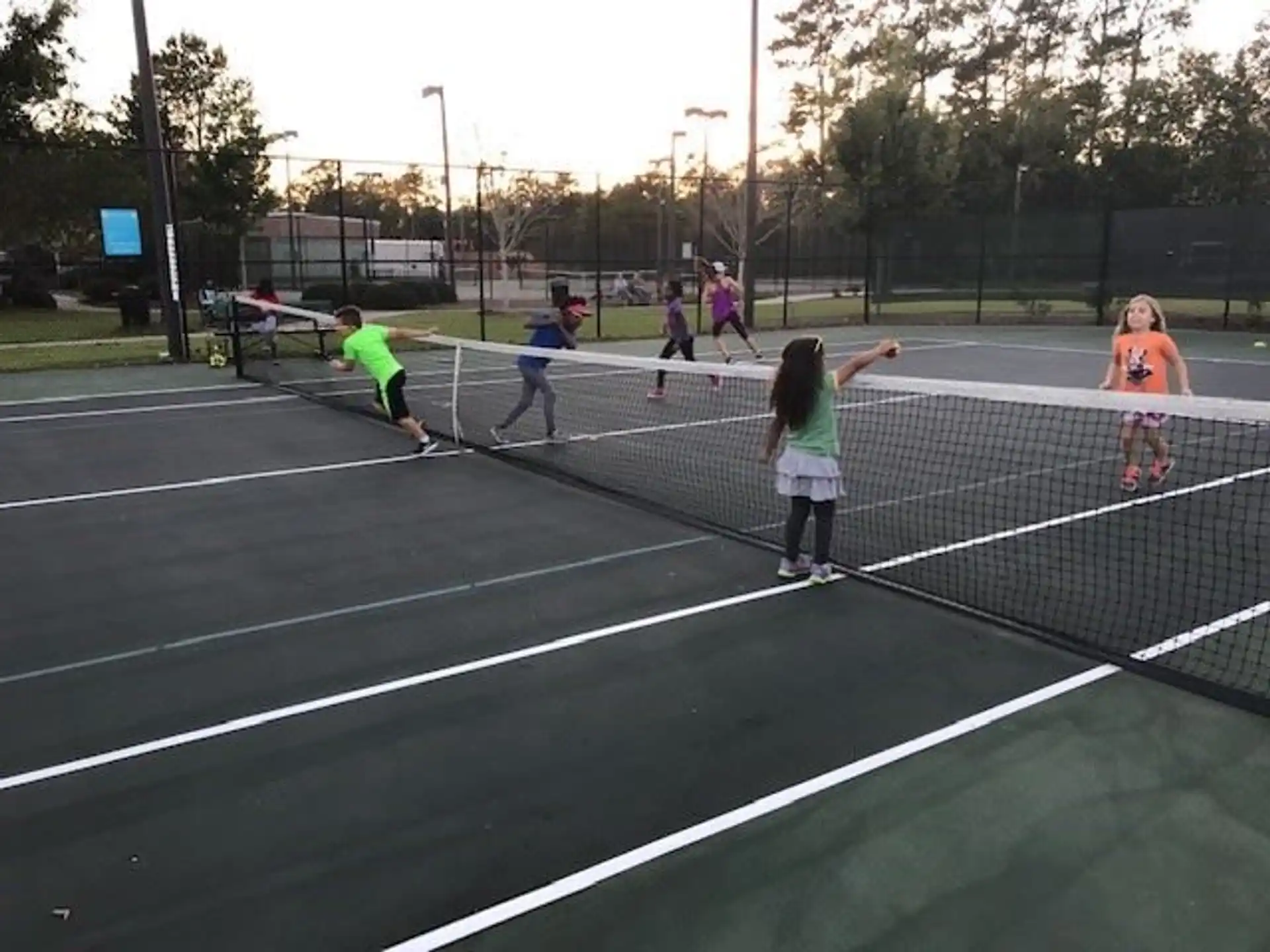 a group of kids playing tennis