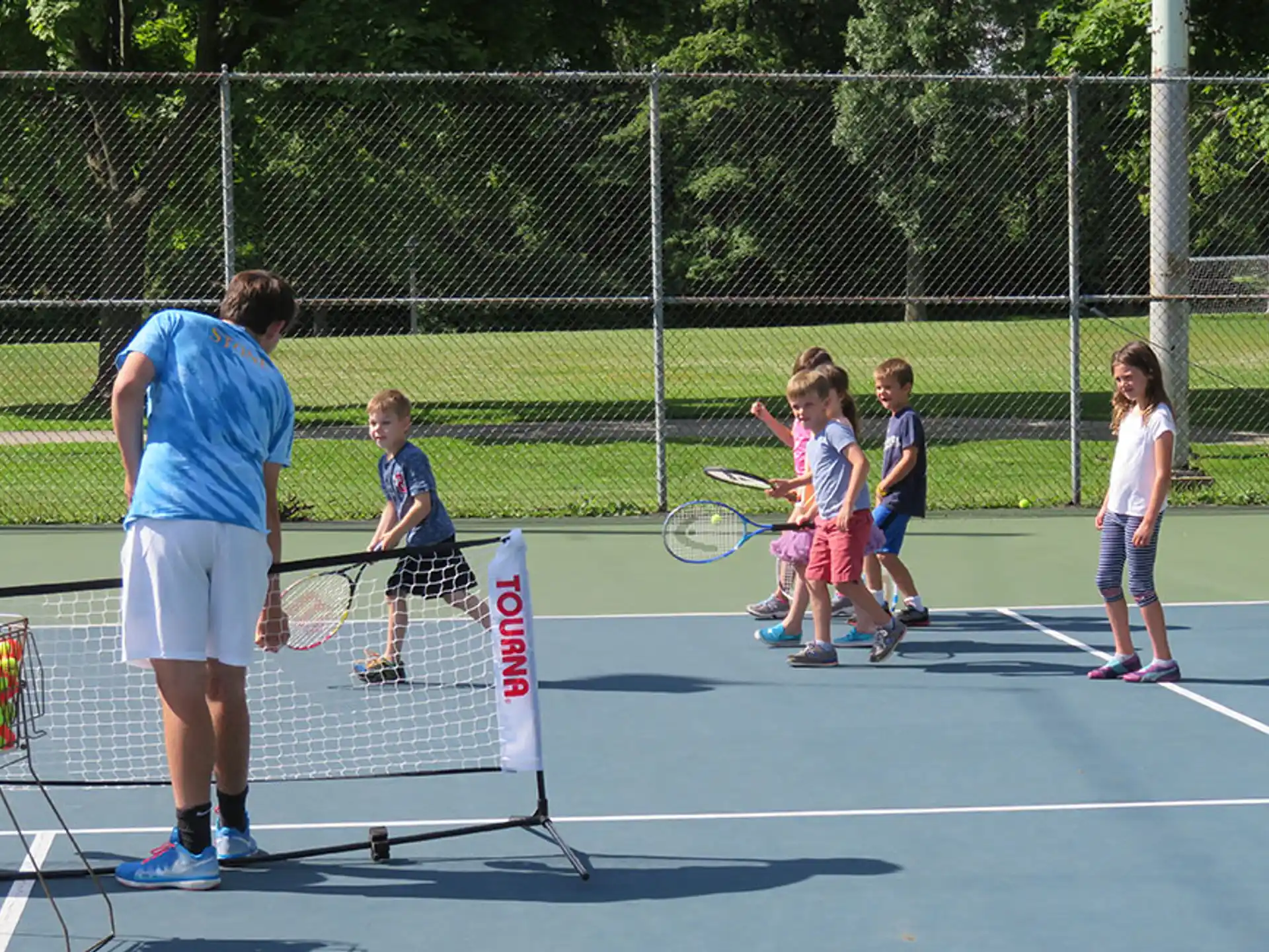 a group of kids playing tennis