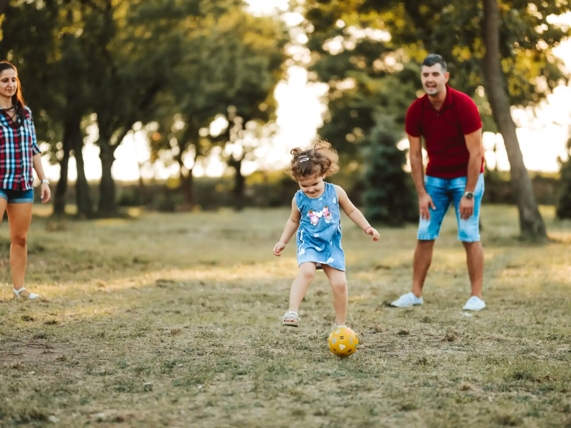 a group of people playing with a ball in a park