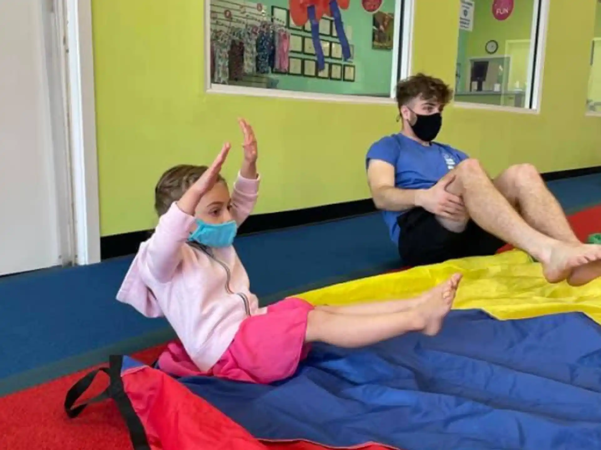 a couple of people wearing masks and sitting on a bed
