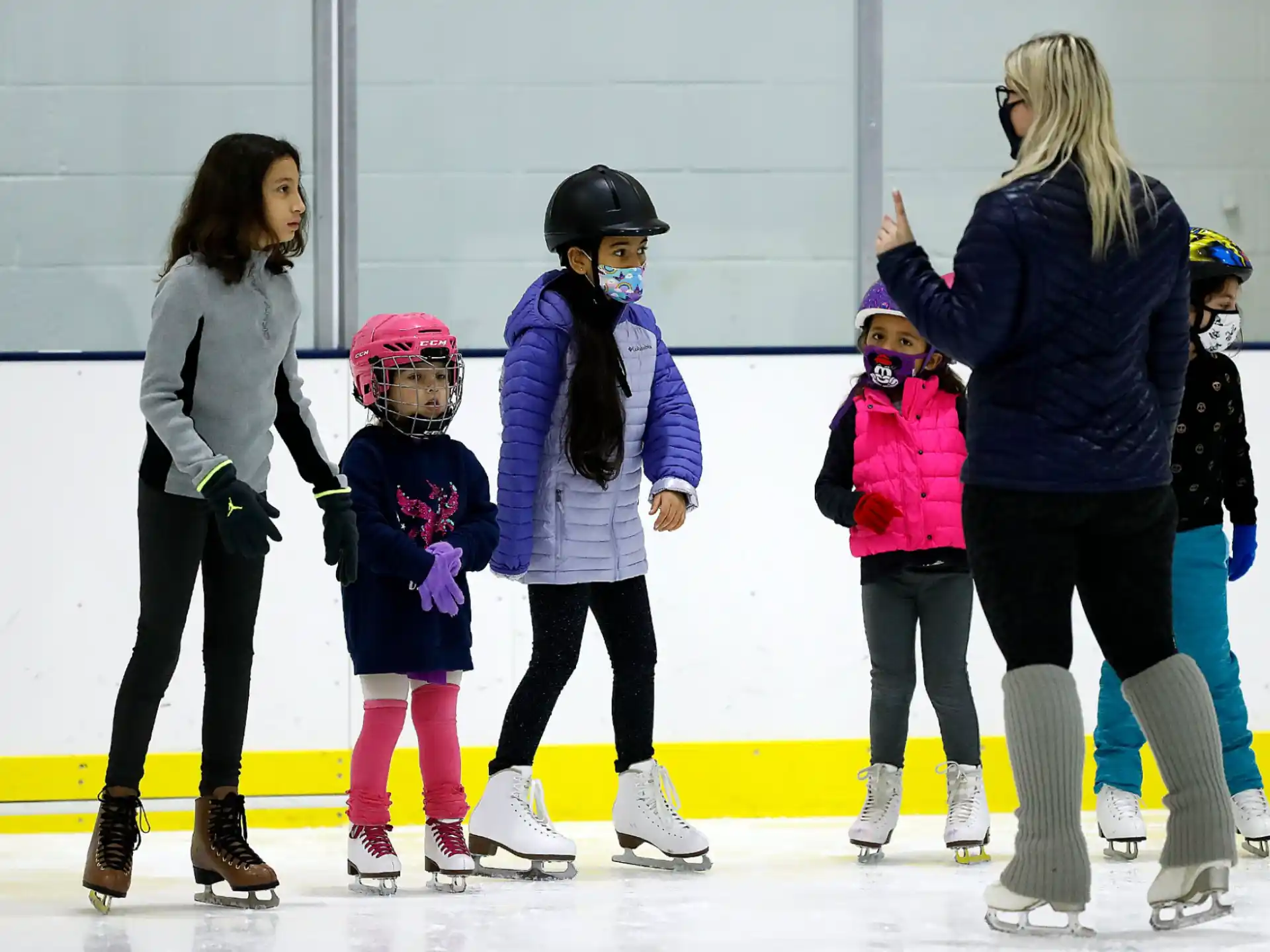 a group of women and children ice skating