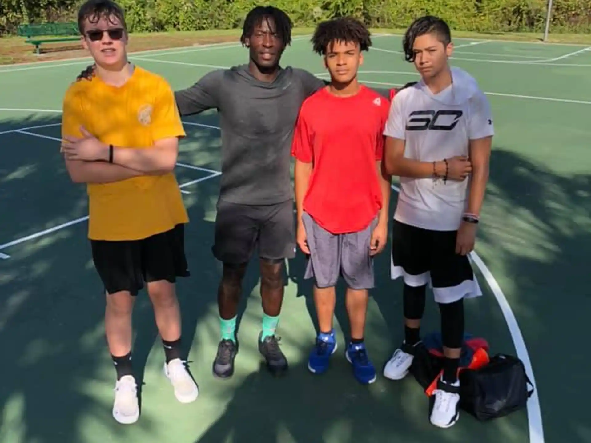 a group of men posing for a picture on a tennis court