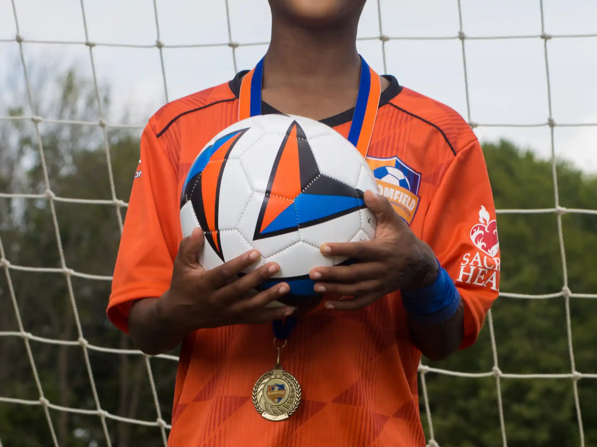 a boy holding a football ball