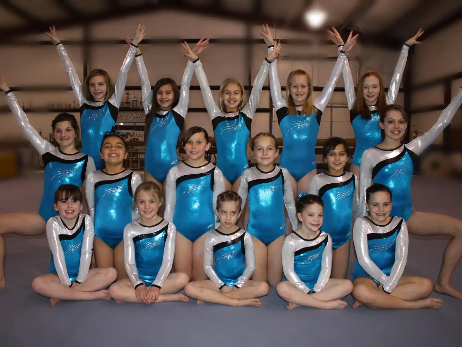 a group of women in blue leotards posing for a photo