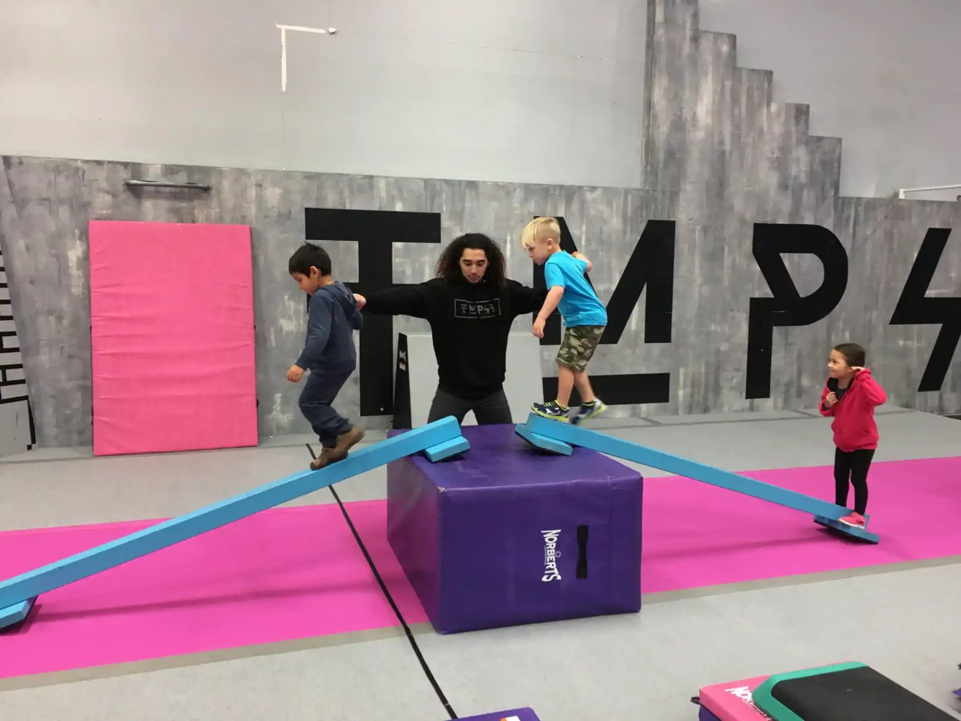 a group of kids playing on a purple mat