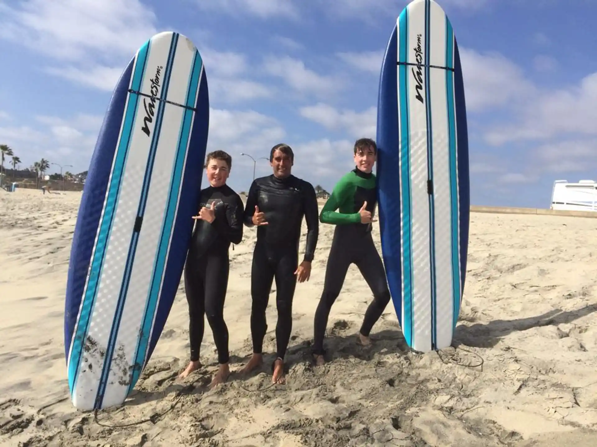 a group of people pose for a picture next to surfboards