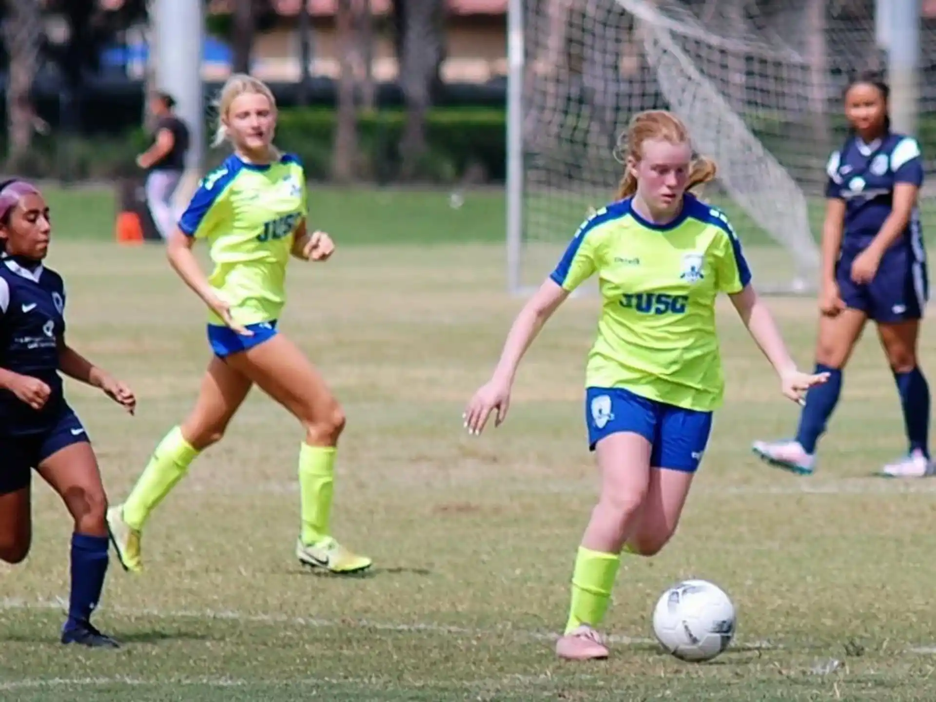 girls playing football on a field