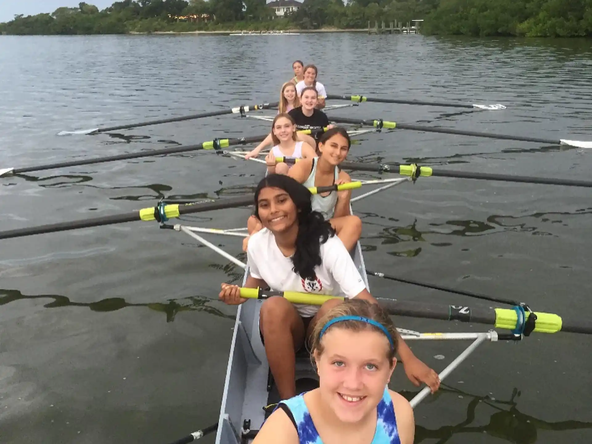 a group of people in a row boat on a lake