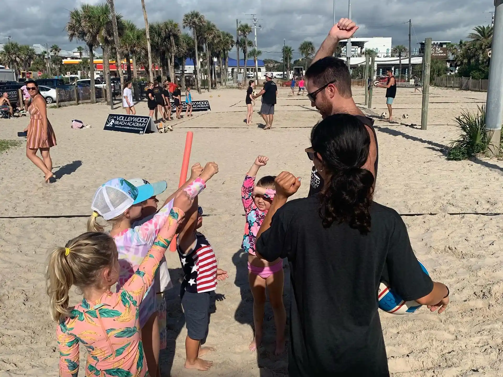a man and woman holding hands with a group of children