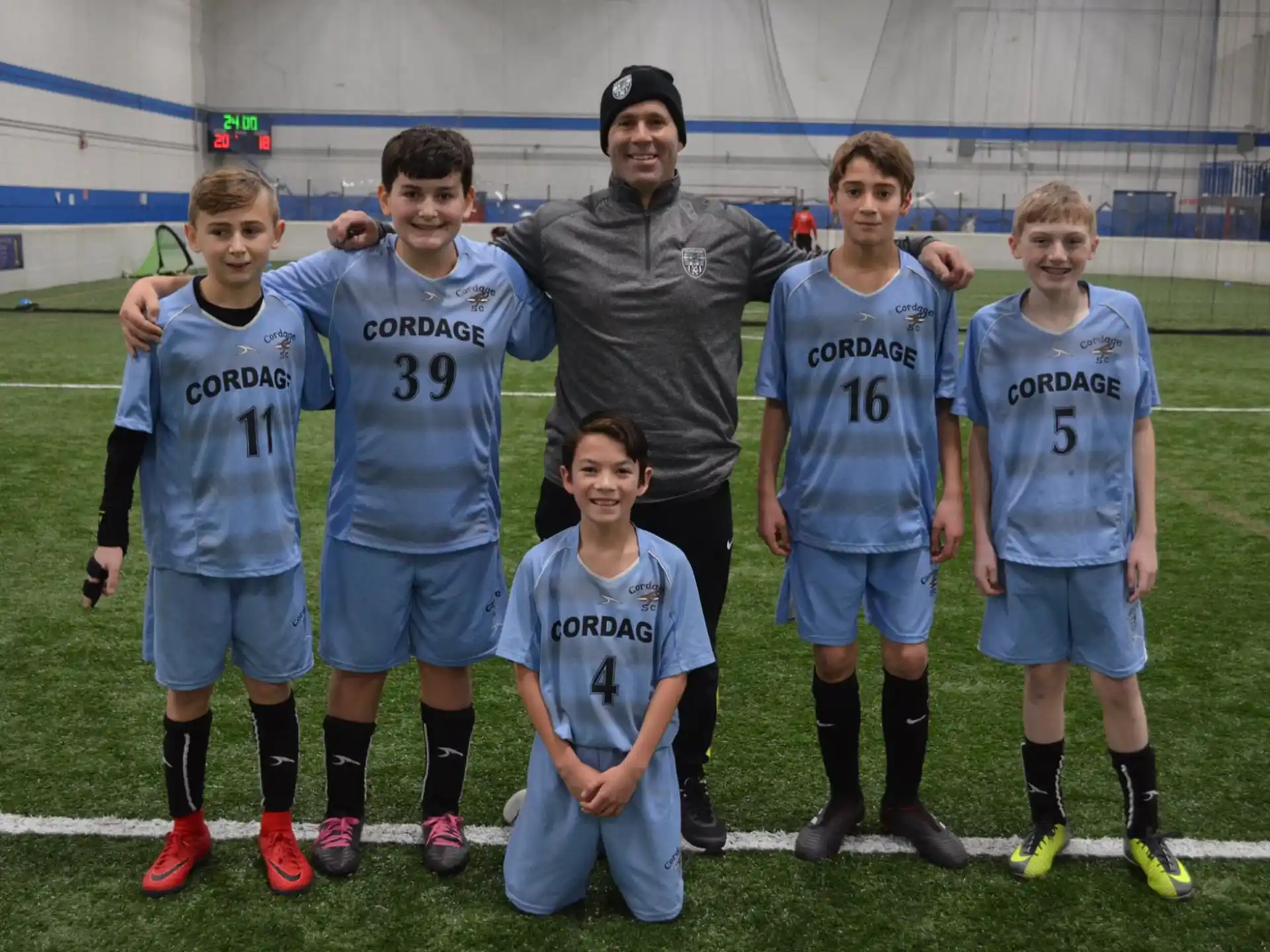 a group of boys posing for a picture on a football field